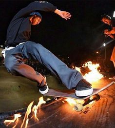 two skateboarders are doing tricks on fire