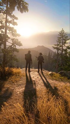 two people standing on top of a mountain with their backs turned to the camera,