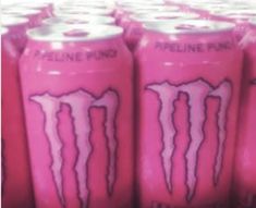 many pink monster energy drinks are lined up