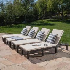 four lounge chairs sitting on top of a stone patio