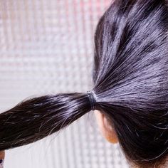 a woman with long black hair has her back to the camera