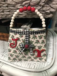 a white basket with red letters and holly on it