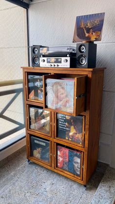 an entertainment center with cd's and cassette players on display in front of a window