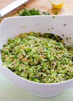 a white bowl filled with broccoli on top of a table