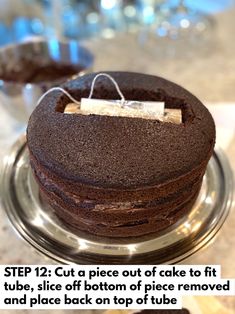 a chocolate cake sitting on top of a metal plate with a tag attached to it