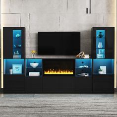 an entertainment center with a fireplace in the middle and blue lighting on it's sides