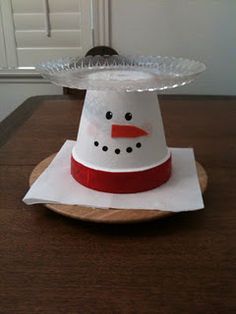 a paper snowman hat sitting on top of a wooden table next to a door