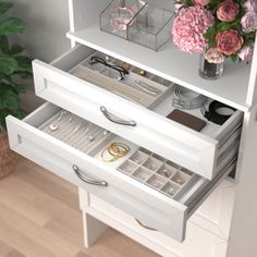 an open drawer with jewelry and flowers in it