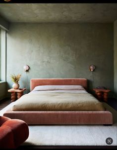 a large bed sitting next to a window in a bedroom on top of a white rug