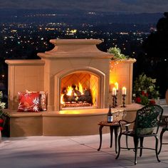 an outdoor fireplace lit up with candles