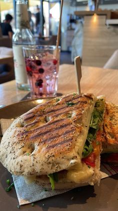 a sandwich cut in half sitting on top of a table next to a glass of water