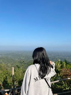 a woman standing on top of a hill looking at the sky