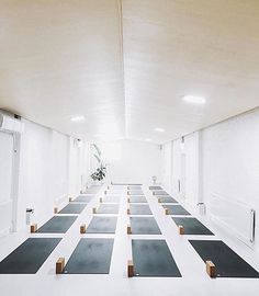 rows of yoga mats are lined up in a room with white walls and flooring