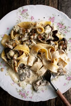 a white plate topped with pasta and mushrooms