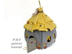 an ornament made to look like a house with a yellow roof and canopy