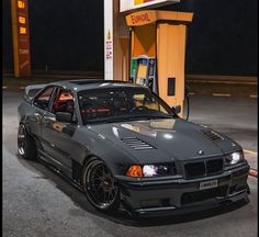 a gray car parked in front of a gas station