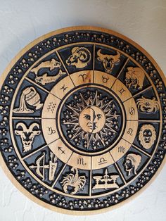 the zodiac sign is mounted on the wall in front of a white wall with black and gold details