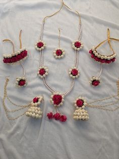 several necklaces with flowers and pearls are arranged on a white sheet