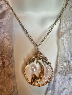 a necklace with a shell and pearls on it