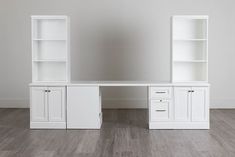 a white desk with two bookcases on top of it in an empty room