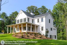 a large white house sitting in the middle of a lush green field with lots of trees