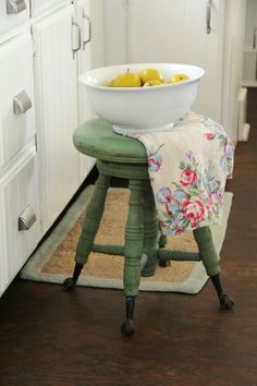 a white bowl with olives in it sitting on a stool next to a kitchen counter