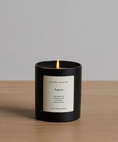 a black candle sitting on top of a wooden table