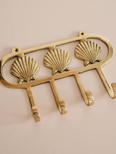 brass plated metal hook with three seashells on it