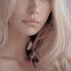 a woman with long blonde hair is looking at the camera while she's wearing a tiara