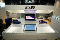 a display case with several different shoes on it's sides and an ipad in the middle