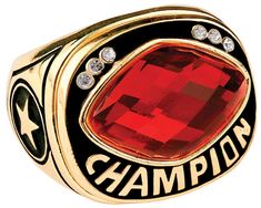 a gold ring with a red stone in the center and words champion written on it