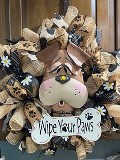 a wreath made to look like a dog's head with the words wipe your paws on it