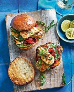 two sandwiches on a cutting board with lemon slices