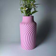 a pink vase with some flowers in it