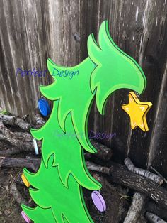 a green wooden christmas tree with stars on it's top and the word design written in blue