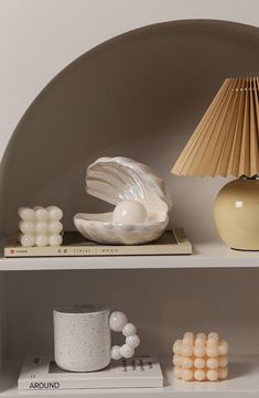 a shelf with two vases, a lamp and other items on top of it