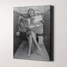 a black and white photo of a woman sitting on a toilet reading a newspaper with her legs crossed