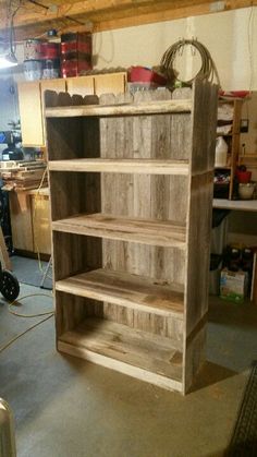 a wooden book shelf in a garage with tools on the floor