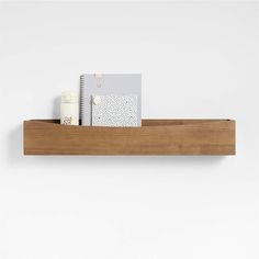 a wooden shelf with two notebooks on it