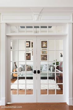 a living room with white walls and glass doors