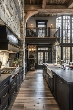 a large kitchen with wood floors and stone walls, along with an open floor plan