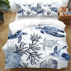 a bed covered in blue and white sea life comforter sets on a wooden floor