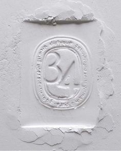 a white wall with an emblem on it and the number three in front of it