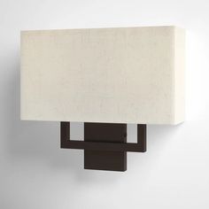 a wall mounted light with a white shade on it's face and back end