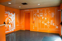 an orange room with white graphics on the walls and floor, in front of a doorway