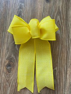 a yellow bow on top of a wooden floor