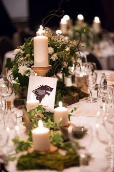 the table is set with candles and greenery