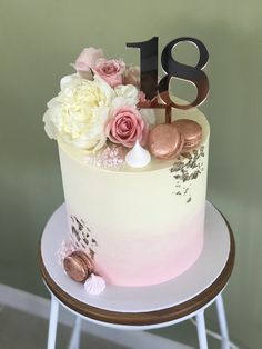 a pink and white cake sitting on top of a table