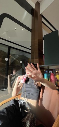 a woman sitting in a chair with her hand up to the ceiling above her head