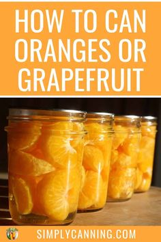 jars filled with oranges sitting on top of a wooden table